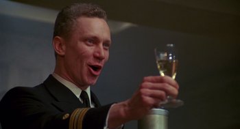 Movie still from “Das Boot” (1981), directed by Wolfgang Petersen – A man holding a glass of wine in his hand; Close Up shot, Low angle