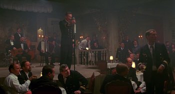 Movie still from “Das Boot” (1981), directed by Wolfgang Petersen – A man in uniform speaking to a crowd; Wide shot, Low angle