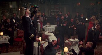 Movie still from “Das Boot” (1981), directed by Wolfgang Petersen – A group of people sitting around a room with drinks; Wide shot, High angle
