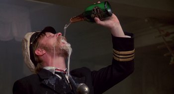 Movie still from “Das Boot” (1981), directed by Wolfgang Petersen – A man in a naval uniform is drinking from a bottle of beer; Close Up shot, Low angle