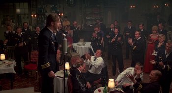 Movie still from “Das Boot” (1981), directed by Wolfgang Petersen – A group of people sitting in a room; Wide shot, Over the shoulder angle