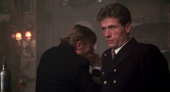 Movie still from “Das Boot” (1981), directed by Wolfgang Petersen – A man in a suit and tie standing next to another man in a suit; Close Up shot, Over the shoulder angle