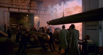 Movie still from “Das Boot” (1981), directed by Wolfgang Petersen – A group of people standing next to a large metal object; Wide shot, High angle