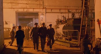 Movie still from “Das Boot” (1981), directed by Wolfgang Petersen – A group of men walking in a warehouse; Extreme Wide shot, High angle