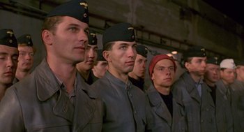 Movie still from “Das Boot” (1981), directed by Wolfgang Petersen – A group of men standing next to each other in military uniforms; Medium shot, Low angle