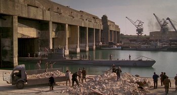 Movie still from “Das Boot” (1981), directed by Wolfgang Petersen – A group of people standing next to a body of water; Extreme Wide shot, High angle