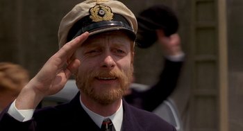 Movie still from “Das Boot” (1981), directed by Wolfgang Petersen – A man with a beard wearing a hat saluting; Close Up shot, Low angle