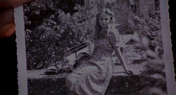 Movie still from “Das Boot” (1981), directed by Wolfgang Petersen – An old photo of a young girl sitting on a bench; Medium shot, High angle