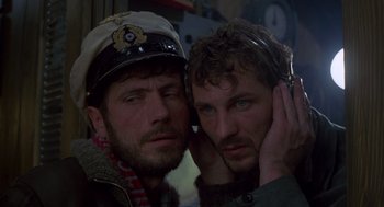 Movie still from “Das Boot” (1981), directed by Wolfgang Petersen – Two men wearing hats and ear muffs posing for a picture; Close Up shot, Low angle