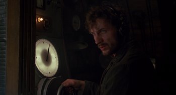 Movie still from “Das Boot” (1981), directed by Wolfgang Petersen – A man with headphones on looking at a clock in a dark room; Close Up shot, Low angle