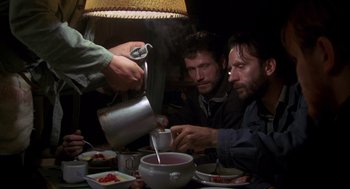 Movie still from “Das Boot” (1981), directed by Wolfgang Petersen – A group of people sitting at a table with food; Medium shot, Low angle