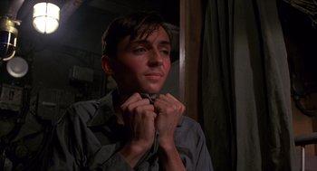 Movie still from “Das Boot” (1981), directed by Wolfgang Petersen – A young man adjusting his tie in front of a mirror; Close Up shot, Low angle