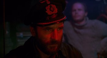 Movie still from “Das Boot” (1981), directed by Wolfgang Petersen – A man wearing a hat and a beard; Close Up shot, Over the shoulder angle