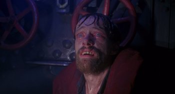 Movie still from “Das Boot” (1981), directed by Wolfgang Petersen – A man with a beard is sitting in a chair; Close Up shot, High angle