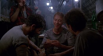 Movie still from “Das Boot” (1981), directed by Wolfgang Petersen – A group of men sitting around a table; Medium shot, High angle