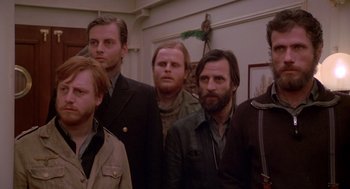 Movie still from “Das Boot” (1981), directed by Wolfgang Petersen – A group of men standing next to each other in a room; Medium shot, Low angle