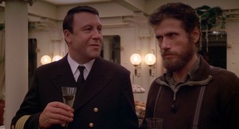 Movie still from “Das Boot” (1981), directed by Wolfgang Petersen – Two men standing next to each other holding wine glasses; Medium shot, Over the shoulder angle