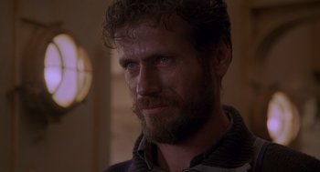 Movie still from “Das Boot” (1981), directed by Wolfgang Petersen – A person with a beard looking at the camera; Close Up shot, Low angle