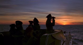 Movie still from “Das Boot” (1981), directed by Wolfgang Petersen – A group of people on a boat watching the sun go down; Extreme Wide shot, Low angle