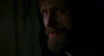 Movie still from “Das Boot” (1981), directed by Wolfgang Petersen – A man with a long beard is looking at the camera; Close Up shot, Over the shoulder angle