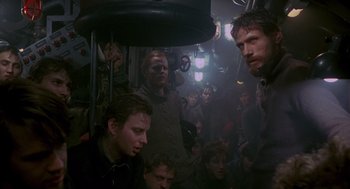Movie still from “Das Boot” (1981), directed by Wolfgang Petersen – A group of people sitting in a room with lights on; Medium shot, High angle