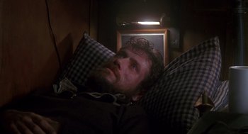 Movie still from “Das Boot” (1981), directed by Wolfgang Petersen – A man laying in a bed with pillows on the floor; Close Up shot, High angle