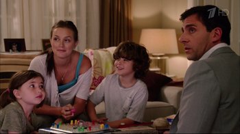 Movie still from “Date Night” (2010), directed by Shawn Levy – A young boy sitting on a woman's lap while playing a board game; Medium shot, Over the shoulder angle