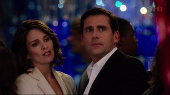 Movie still from “Date Night” (2010), directed by Shawn Levy – A man and a woman standing next to each other in front of lights; Medium shot, Over the shoulder angle