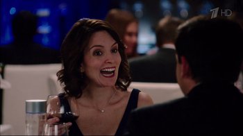 Movie still from “Date Night” (2010), directed by Shawn Levy – A smiling woman holding a glass of red wine; Close Up shot, Over the shoulder angle