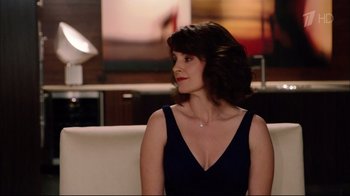 Movie still from “Date Night” (2010), directed by Shawn Levy – A woman sitting on top of a couch in a living room; Medium shot, Over the shoulder angle