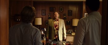 Movie still from “The Internship” (2013), directed by Shawn Levy – A man standing in front of a mirror in a room; Medium shot, Over the shoulder angle