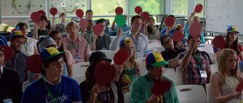 Movie still from “The Internship” (2013), directed by Shawn Levy – A group of people sitting in a room holding red hearts; Medium shot, High angle