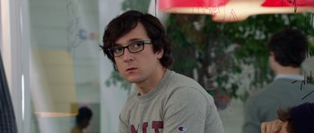 Movie still from “The Internship” (2013), directed by Shawn Levy – A young man with glasses and a gray shirt; Close Up shot, Over the shoulder angle