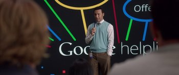 Movie still from “The Internship” (2013), directed by Shawn Levy – A man standing in front of a microphone on a stage; Medium shot, Over the shoulder angle