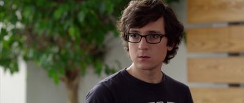 Movie still from “The Internship” (2013), directed by Shawn Levy – A young man wearing glasses and a t - shirt looks to his left; Close Up shot, Over the shoulder angle