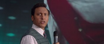 Movie still from “The Internship” (2013), directed by Shawn Levy – A man holding a microphone in front of a microphone stand; Close Up shot, Low angle