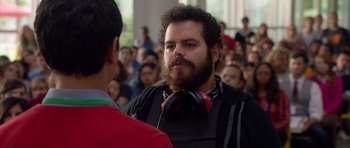 Movie still from “The Internship” (2013), directed by Shawn Levy – A man with a beard wearing headphones in front of a crowd of onlookers; Close Up shot, Over the shoulder angle
