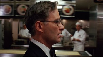 Movie still from “Dave” (1993), directed by Ivan Reitman – A person wearing a suit and glasses; Close Up shot, Over the shoulder angle