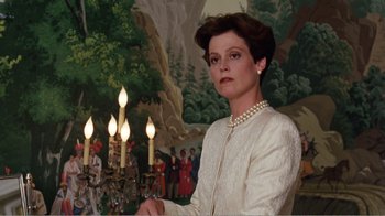 Movie still from “Dave” (1993), directed by Ivan Reitman – A woman standing in front of a painting with candles; Medium shot, Low angle