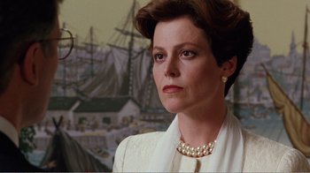 Movie still from “Dave” (1993), directed by Ivan Reitman – A person wearing a suit and pearls; Close Up shot, Low angle