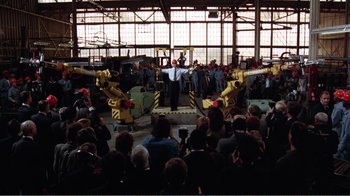 Movie still from “Dave” (1993), directed by Ivan Reitman – A group of people standing in front of a group of robots; Extreme Wide shot, High angle