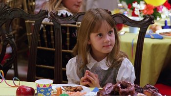 Movie still from “Dave” (1993), directed by Ivan Reitman – A little girl sitting at a table with a lot of food; Close Up shot, High angle