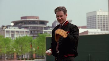 Movie still from “Dave” (1993), directed by Ivan Reitman – A man holding a baseball glove and a ball in his hand; Medium shot, Over the shoulder angle