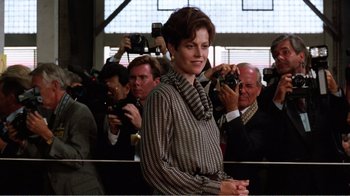 Movie still from “Dave” (1993), directed by Ivan Reitman – A woman taking a picture in front of a crowd; Medium shot, Low angle