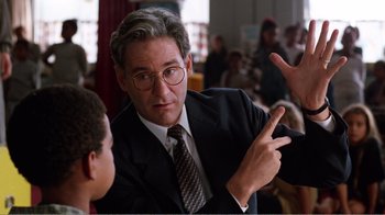 Movie still from “Dave” (1993), directed by Ivan Reitman – A man in a suit and tie pointing at something; Close Up shot, Low angle