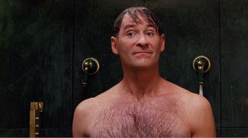 Movie still from “Dave” (1993), directed by Ivan Reitman – A shirtless man in the shower looking at the camera; Close Up shot, Low angle