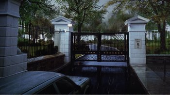 Movie still from “Dave” (1993), directed by Ivan Reitman – A car parked in front of a gated driveway; Extreme Wide shot, High angle