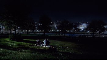 Movie still from “Dave” (1993), directed by Ivan Reitman – Two people sitting on a blanket in a park at night; Extreme Wide shot, High angle