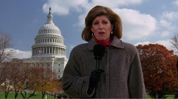 Movie still from “Dave” (1993), directed by Ivan Reitman – A woman is holding a microphone in front of the capitol building; Medium shot, Low angle