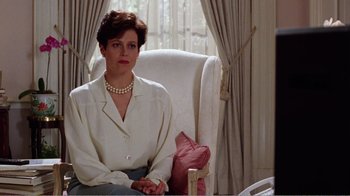 Movie still from “Dave” (1993), directed by Ivan Reitman – A woman sitting in a chair wearing a white blouse; Medium shot, Low angle